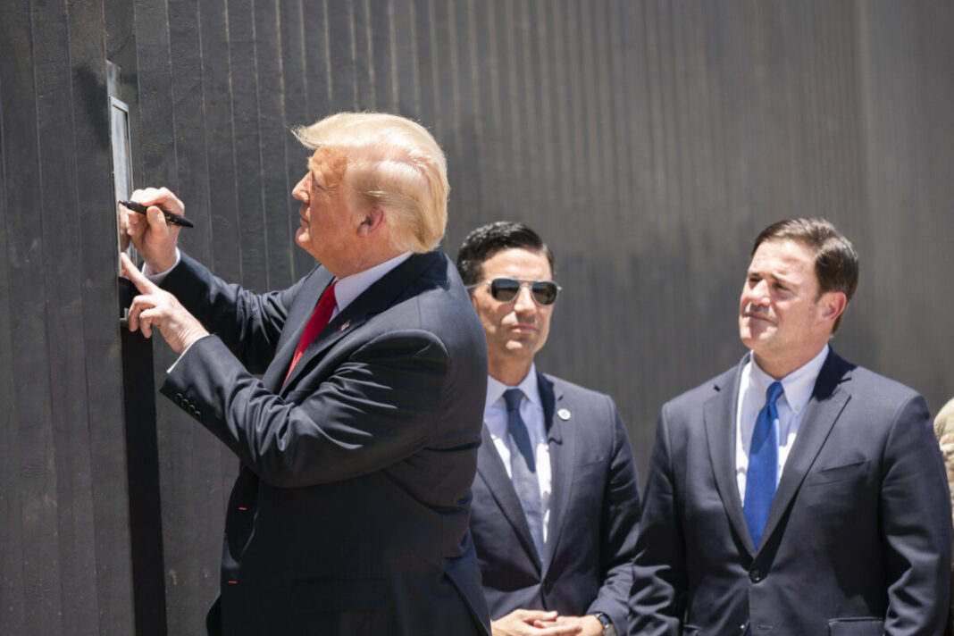 trump signs a plaque commemorating the 200th mile of new border wall along the U.S-Mexico border